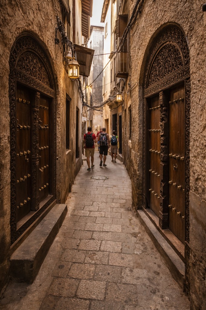Narrow Stone Town alley with ornate carved wooden doors